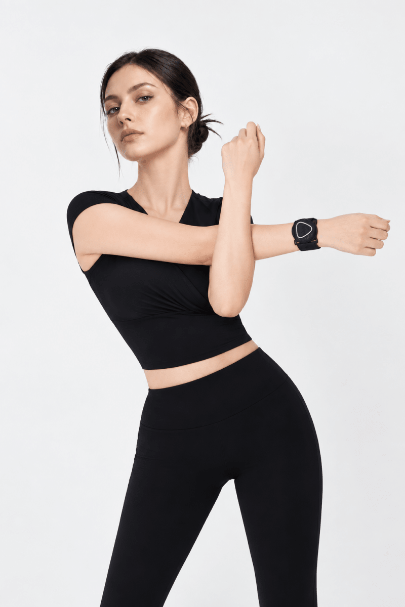 Woman in black athletic wear with an Aalok Band Single on a white background