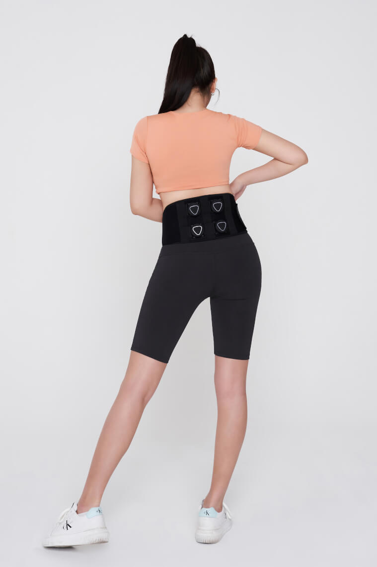 Person wearing Aalok Band Quad, a peach top, and black shorts with heart designs on a white background