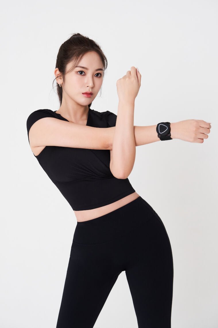 Woman in black athletic wear with an Aalok Band Single on a white background