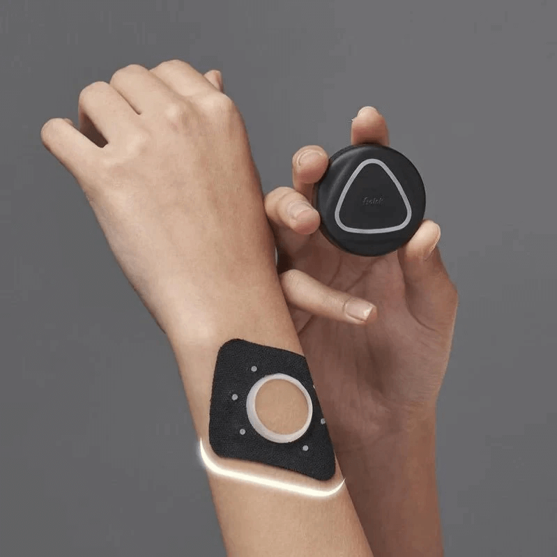 A person wearing an Aalok Pach device on their wrist with a matching device held above.