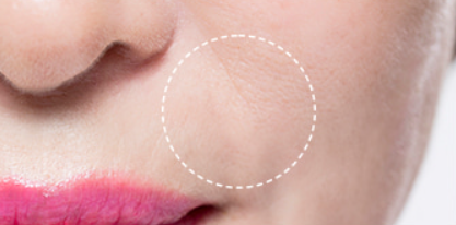 Close-up of a person's mouth with pink lipstick and a blurred background