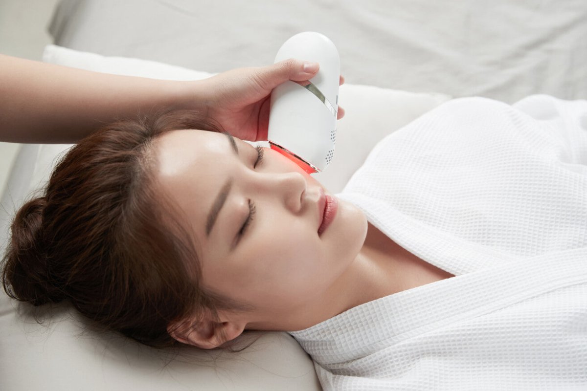 A woman receiving a facial treatment with aAalok Snowfit on her face