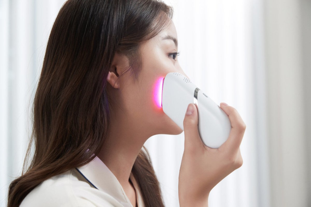 Woman using Aalok Snowfit on her face with a blurred background