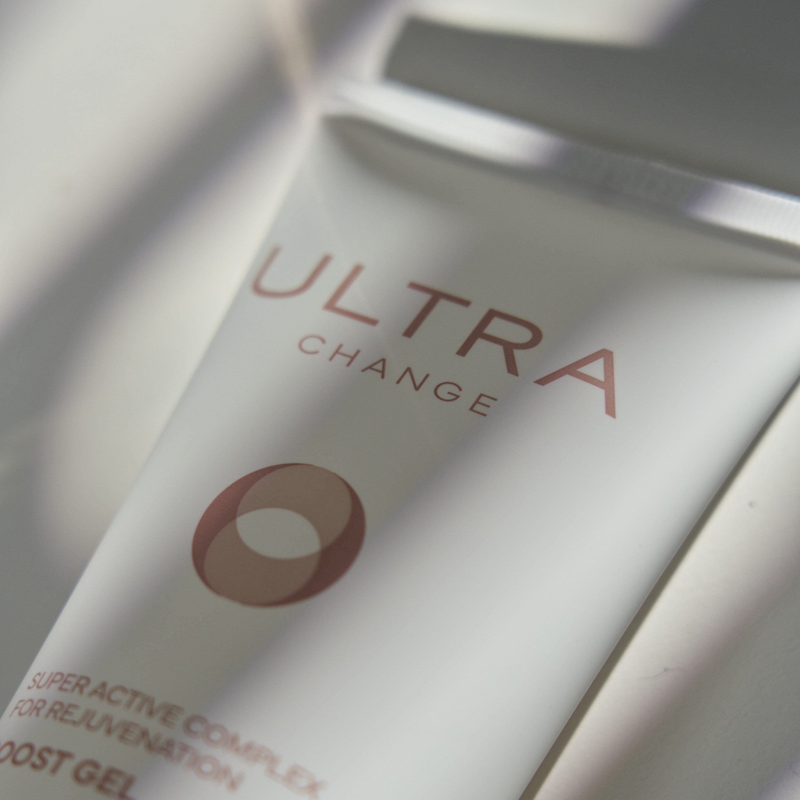 Close-up of a skincare product labeled 'Ultra Change' with a blurred background.