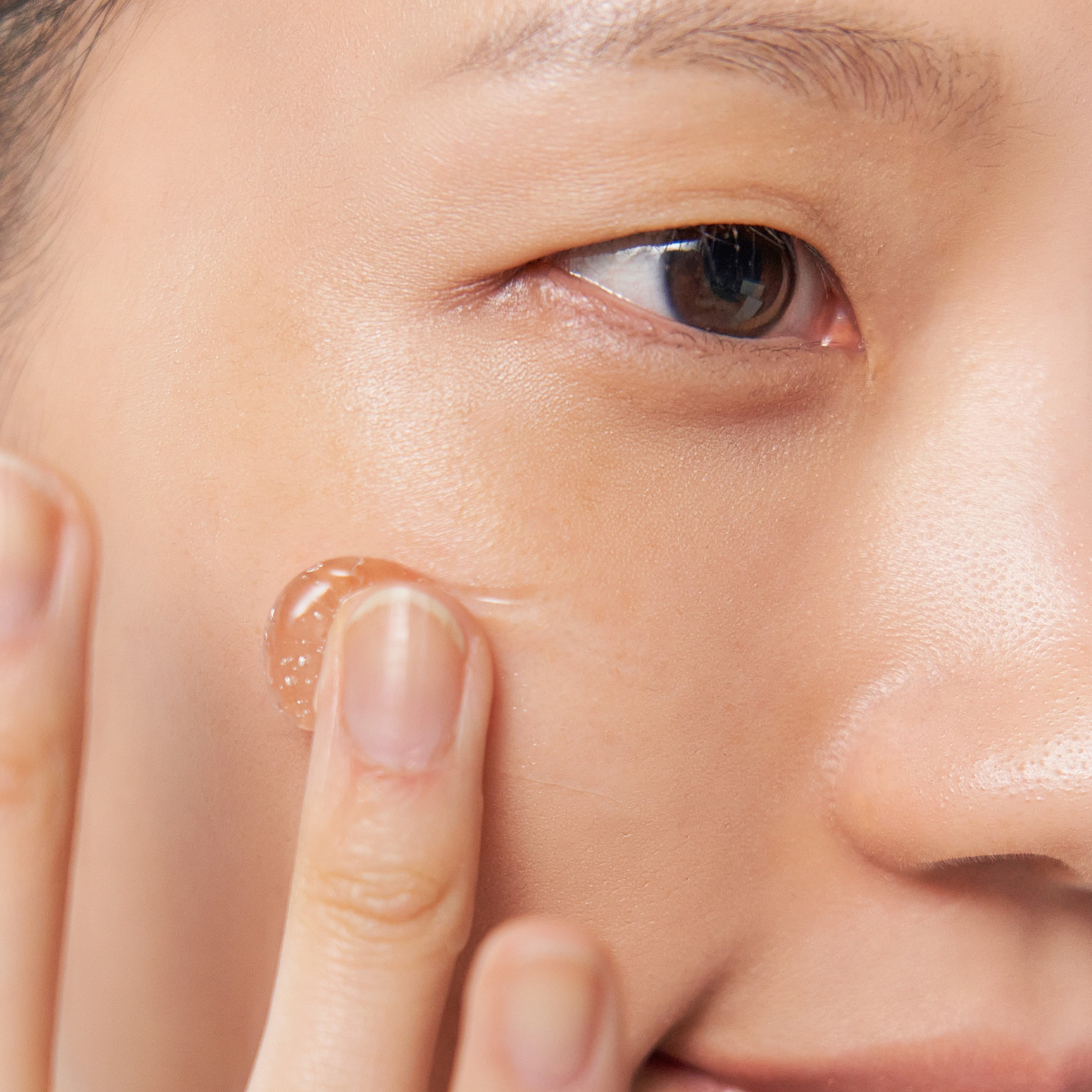 Close-up of a person applying Aalok Ultra Change Boost Gel to their face

