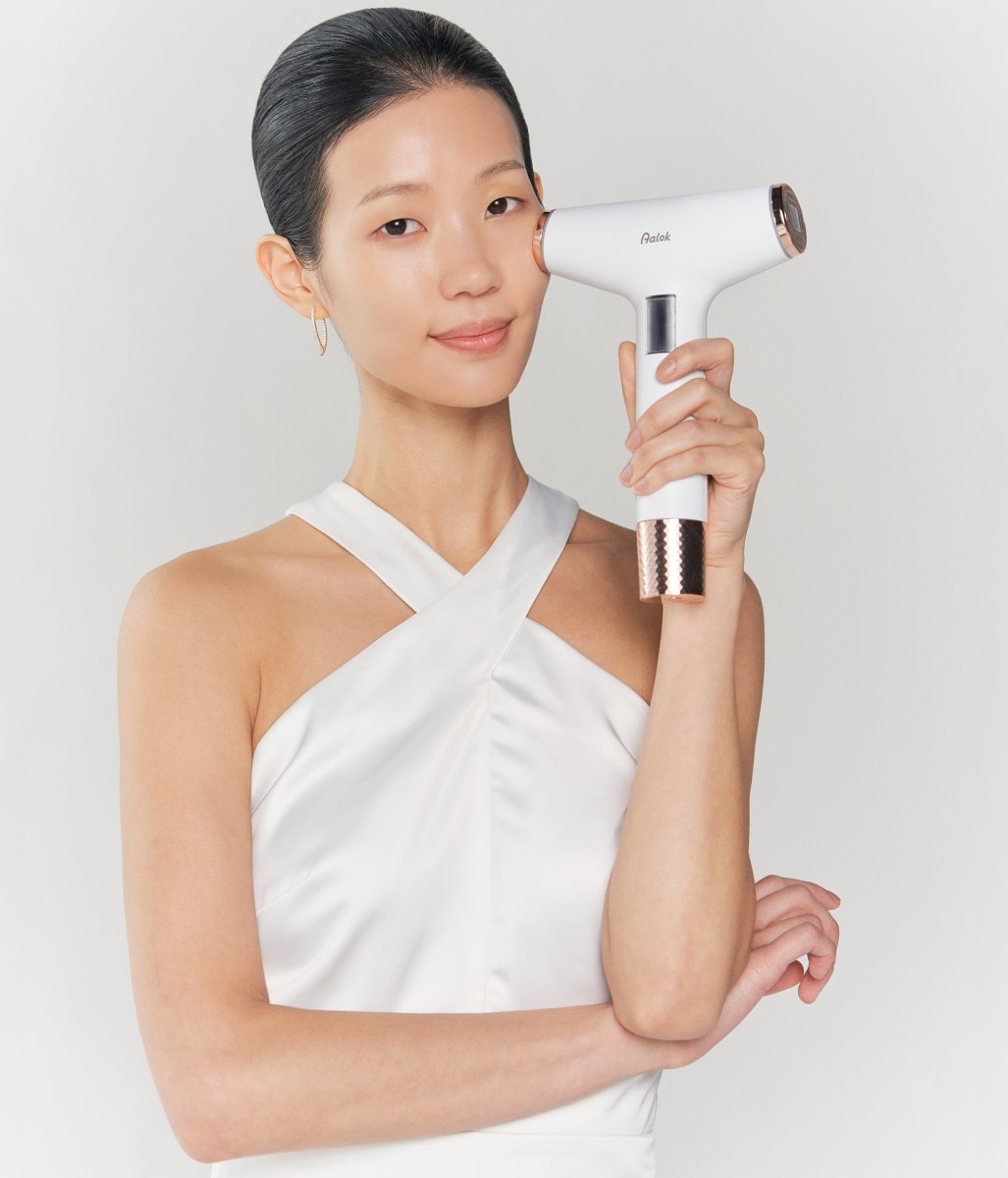 Woman using Aalok Ultra Change Pocus on her cheek against a plain background