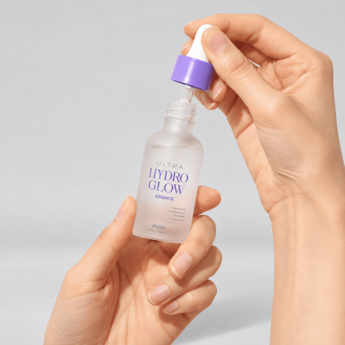 Hand holding a bottle labeled 'Ultra Hydro Glow' against a light background

